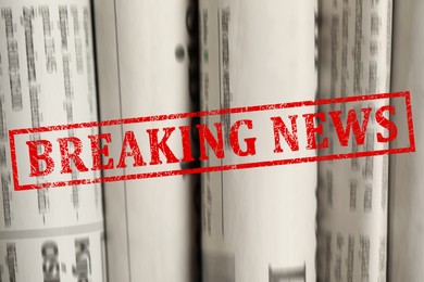 Image of Red Breaking News stamp and newspapers as background, closeup