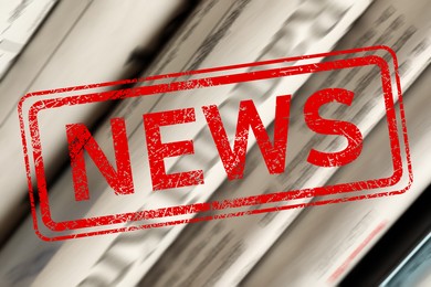 Image of Red News stamp and newspapers as background, closeup