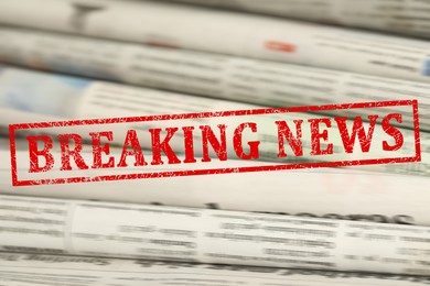 Image of Red Breaking News stamp and newspapers as background, closeup