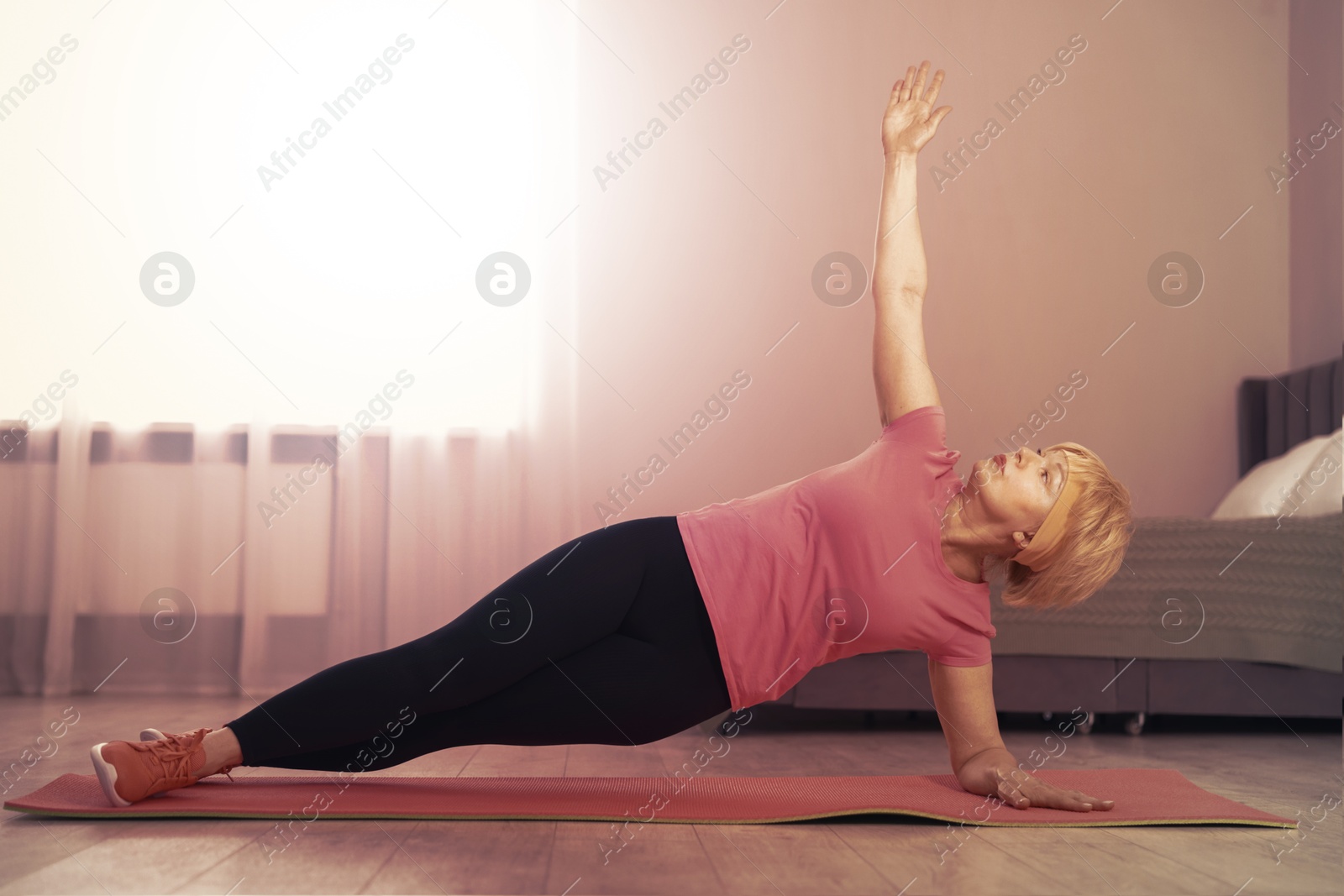 Woman doing side plank exercise on fitness mat at home. Sport and healthy lifestyle Image of Woman doing side plank exercise on fitness mat at home. Sport and healthy lifestyle