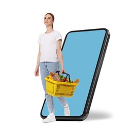 Image of Woman with shopping basket full of products walking out of mobile phone against white background. Online ordering