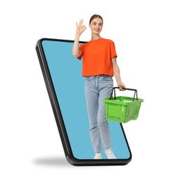 Image of Woman with shopping basket showing ok out of mobile phone against white background. Online ordering