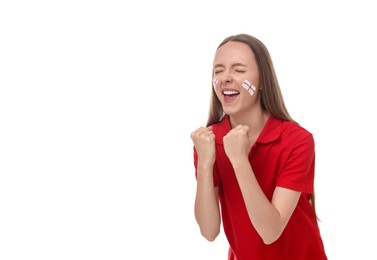 Image of Excited fan with flags of England painted on her face against white background. Space for text