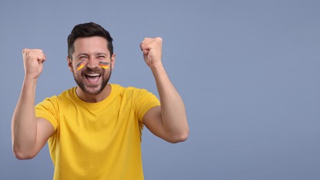 Image of Happy fan with flags of Germany painted on his face against grey background. Banner design with space for text