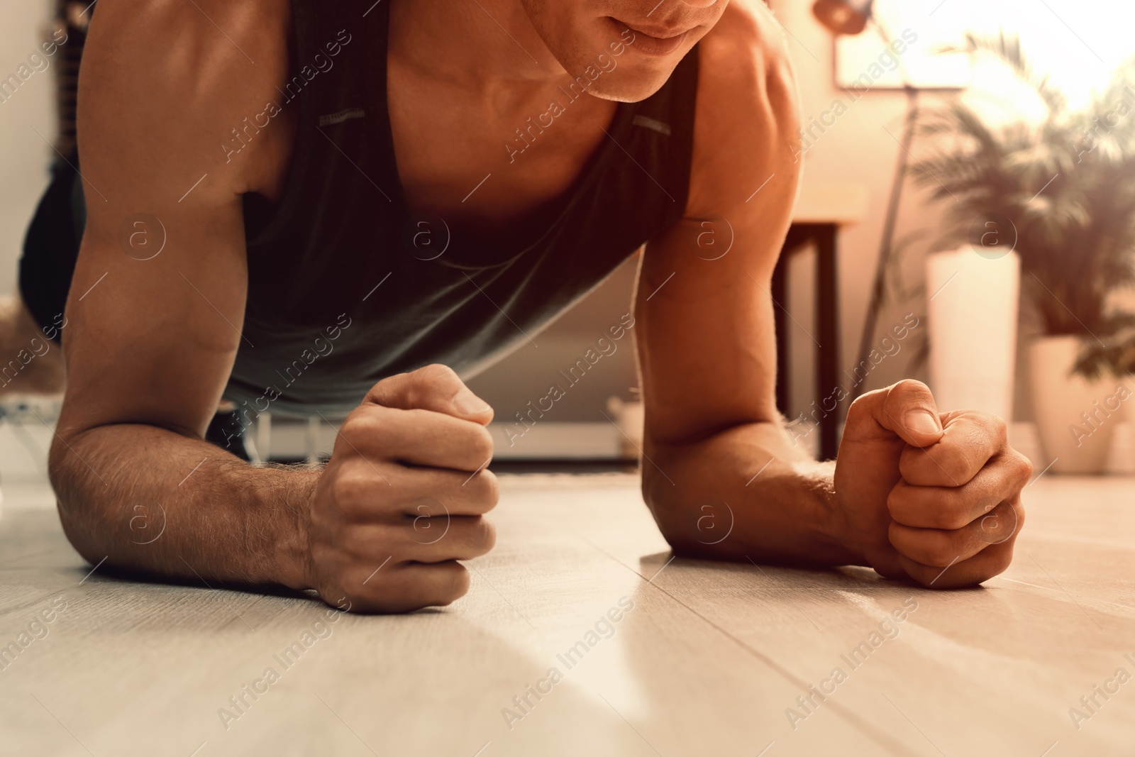 Sporty man doing plank exercise on floor at home, closeup Image of Sporty man doing plank exercise on floor at home, closeup