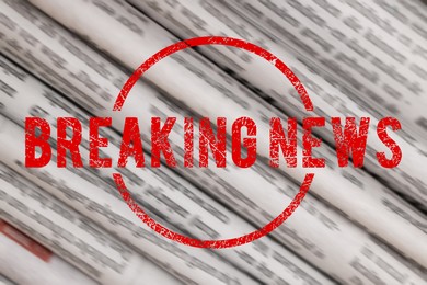 Image of Red Breaking News stamp and newspapers as background, closeup