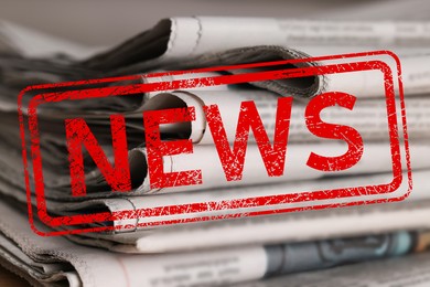 Image of Red News stamp and many newspapers on table, closeup