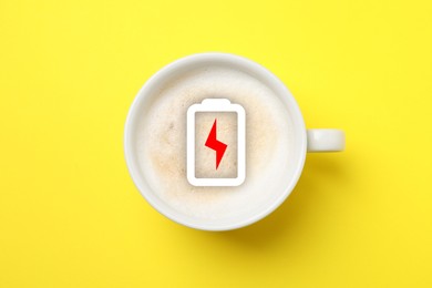 Image of Cup of coffee with battery indicator on yellow background, top view. Restoring energy with caffeine