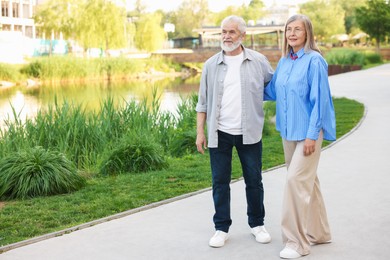 Photo of Lovely senior couple walking together in park