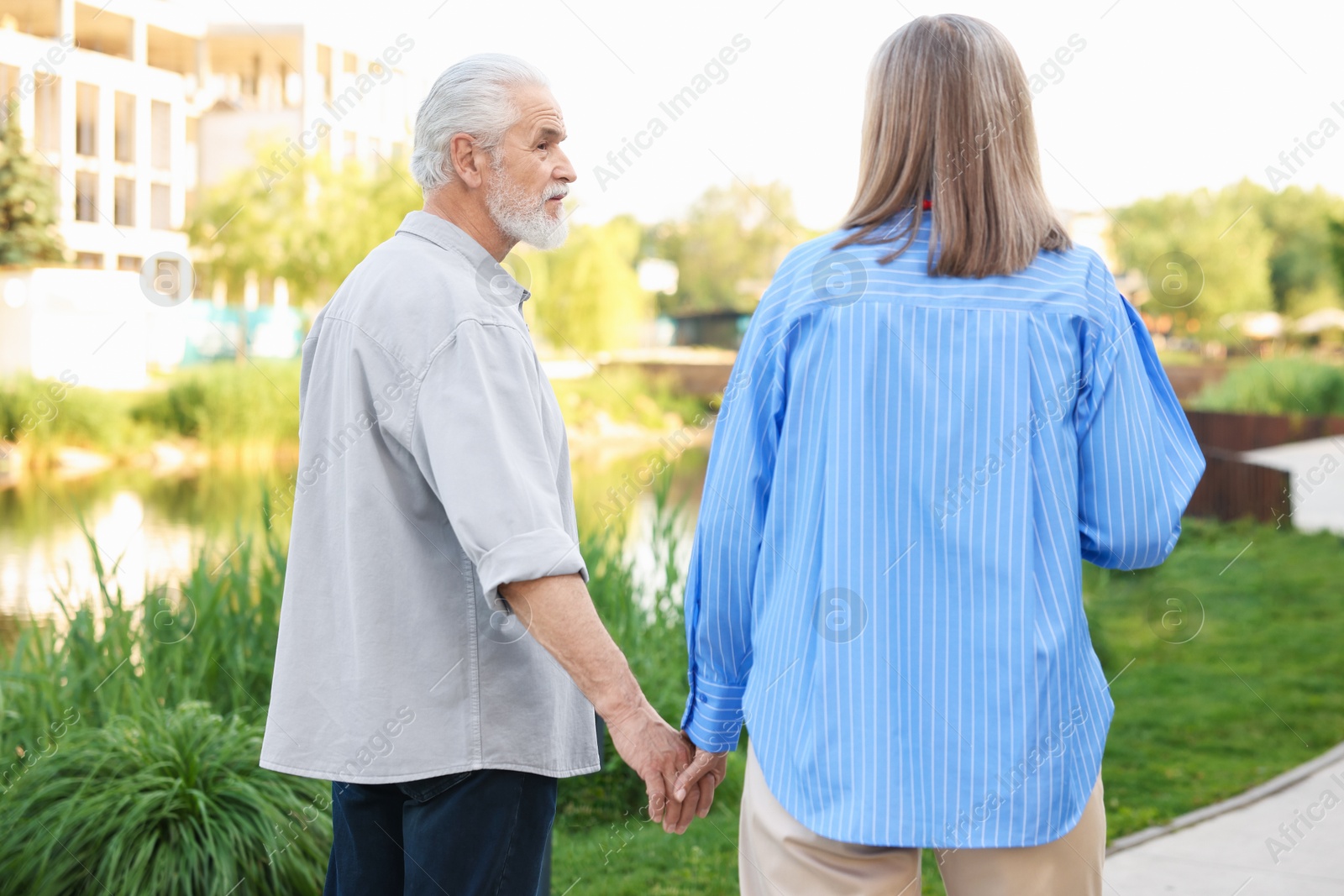 Photo of Lovely senior couple walking together in park