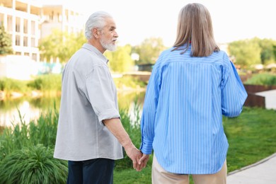 Photo of Lovely senior couple walking together in park