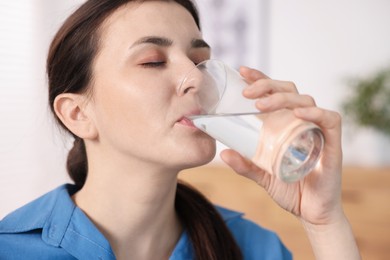 Photo of Woman drinking water from glass at home