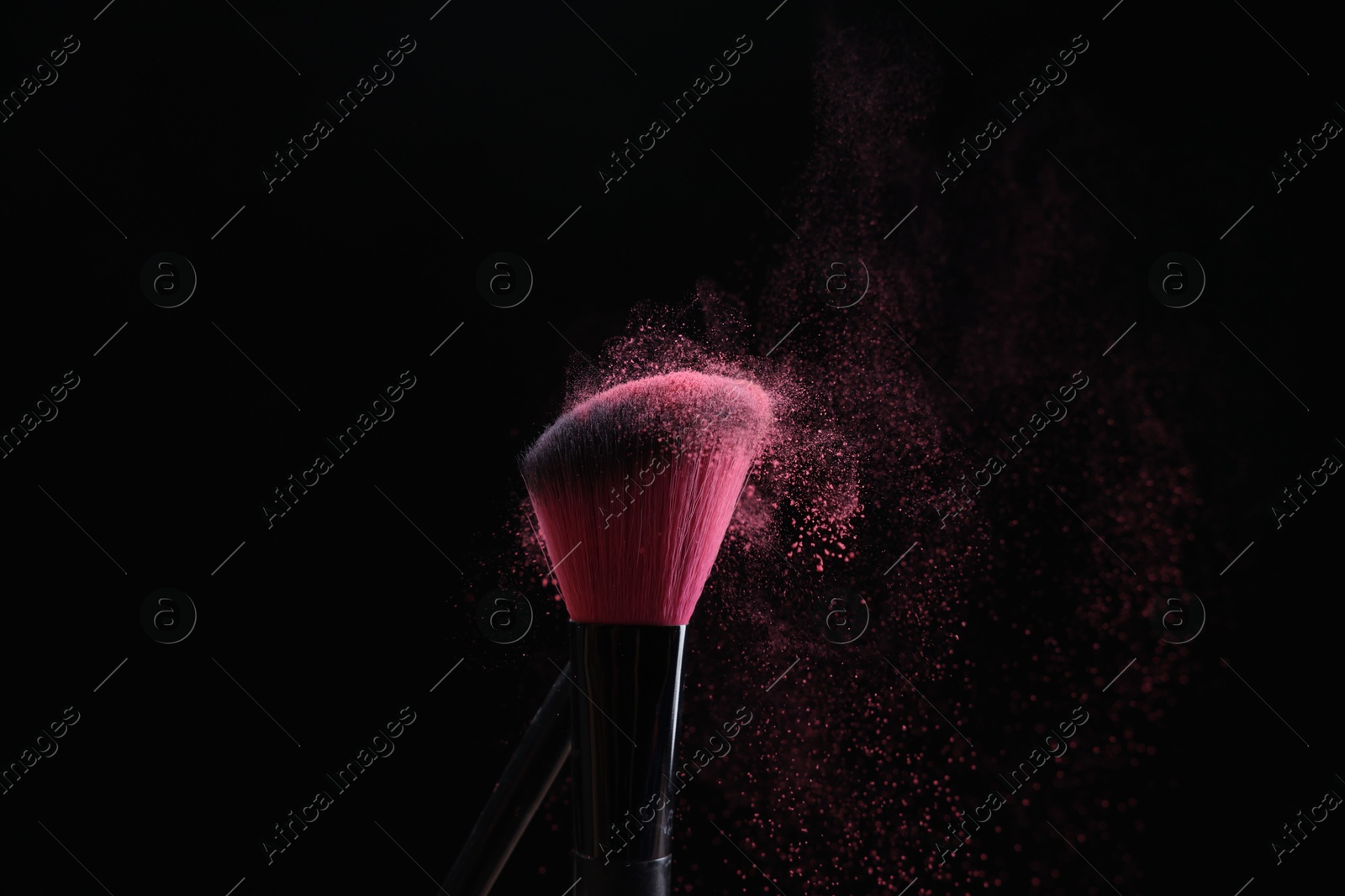Makeup brushes with pink eye shadow on black background, closeup Photo of Makeup brushes with pink eye shadow on black background, closeup
