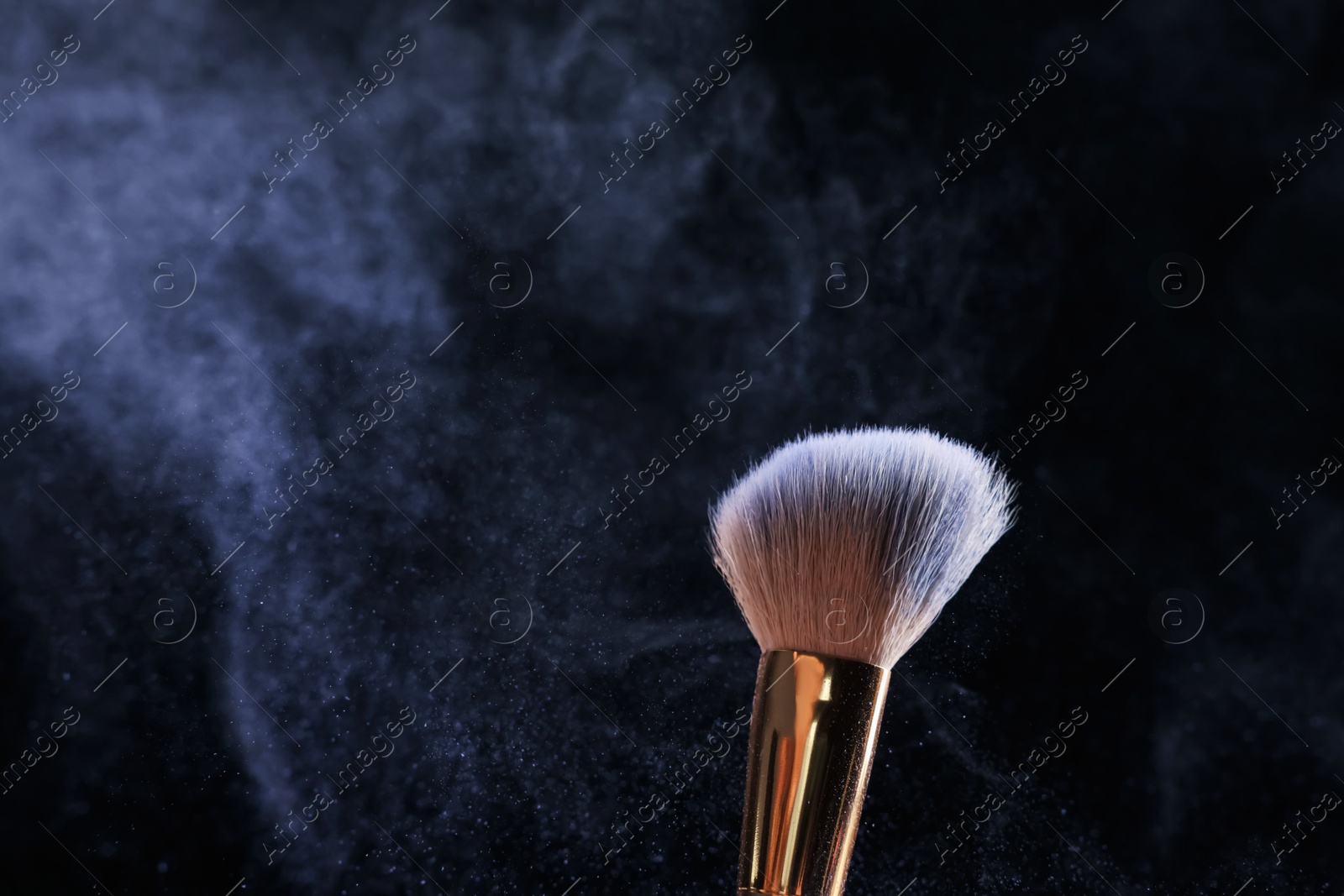 Makeup brush with cosmetic product on black background, closeup Photo of Makeup brush with cosmetic product on black background, closeup