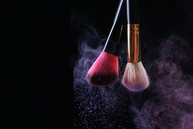 Photo of Makeup brushes with colorful eye shadows on black background, closeup. Space for text