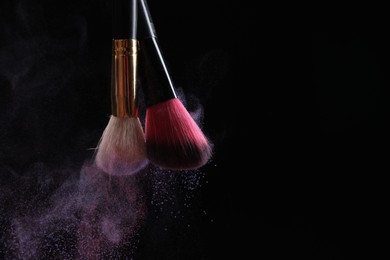 Photo of Makeup brushes with colorful eye shadows on black background, closeup. Space for text