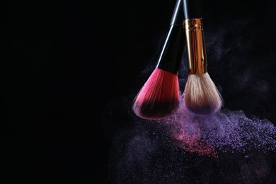Photo of Makeup brushes with colorful eye shadows on black background, closeup. Space for text