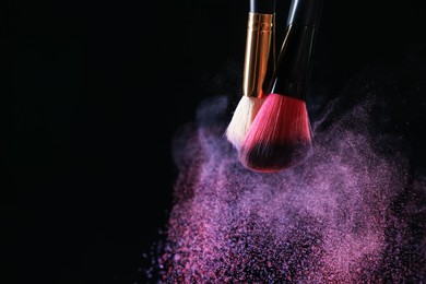 Photo of Makeup brushes with colorful eye shadows on black background, closeup. Space for text