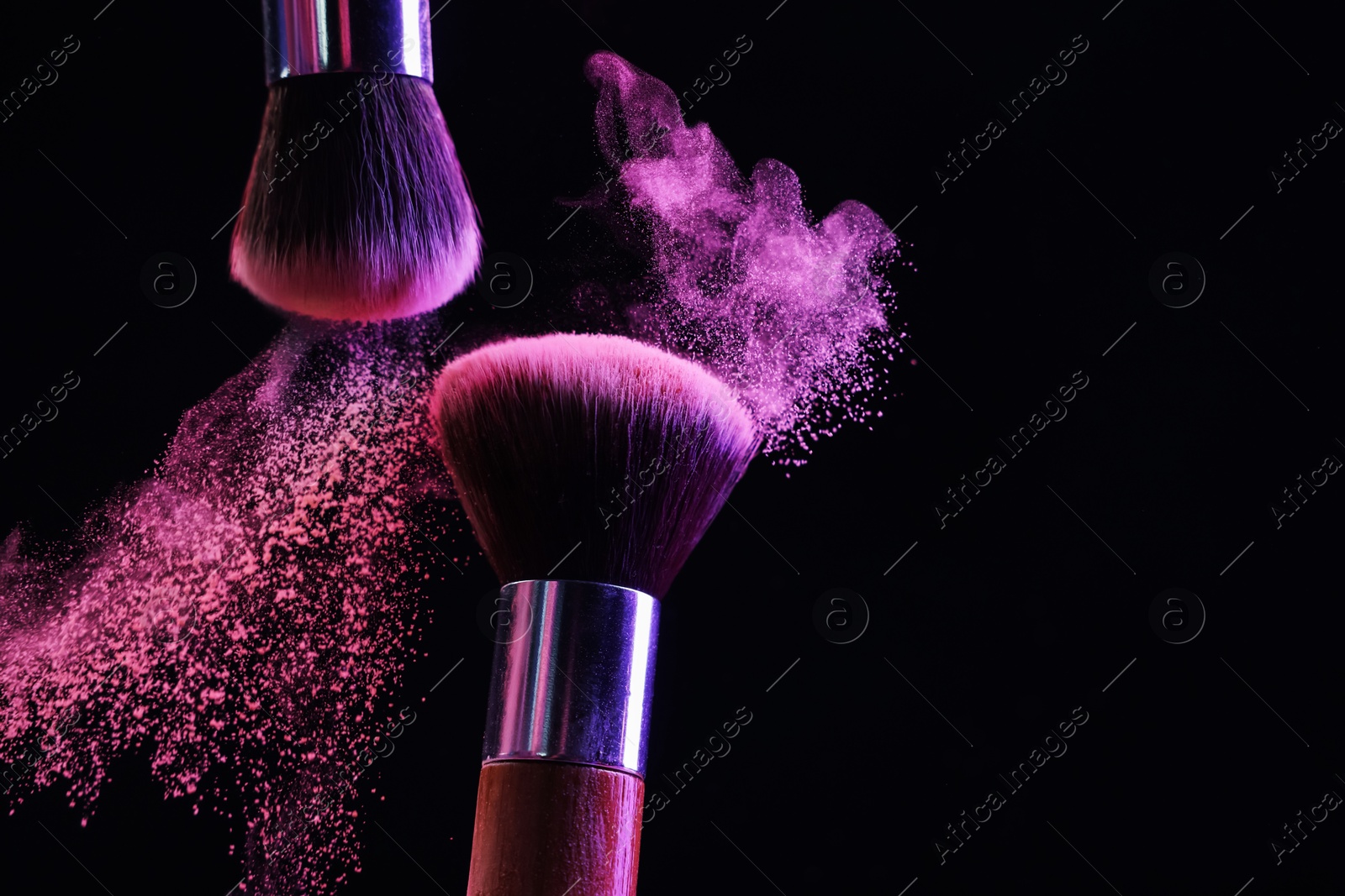 Makeup brushes with colorful eye shadows in neon lights on black background, closeup. Space for text Photo of Makeup brushes with colorful eye shadows in neon lights on black background, closeup. Space for text