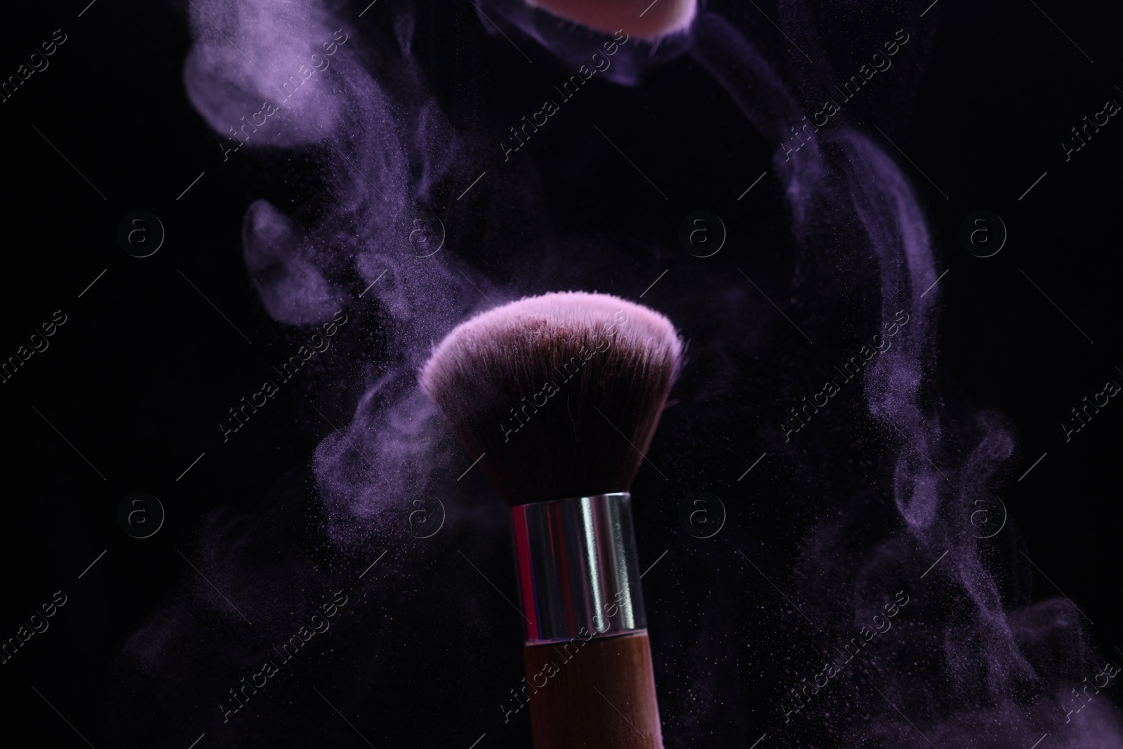 Makeup brush with purple eye shadow on black background, closeup Photo of Makeup brush with purple eye shadow on black background, closeup