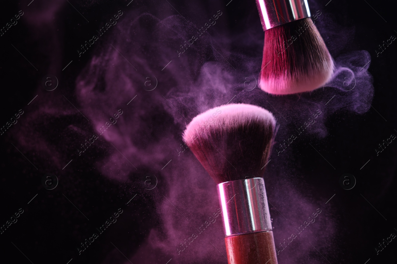 Makeup brushes with colorful eye shadows in neon lights on black background, closeup. Space for text Photo of Makeup brushes with colorful eye shadows in neon lights on black background, closeup. Space for text