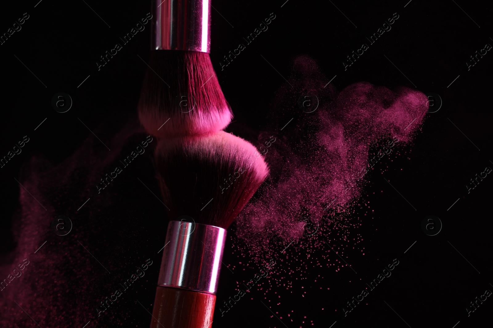 Makeup brushes with pink eye shadow on black background, closeup. Space for text Photo of Makeup brushes with pink eye shadow on black background, closeup. Space for text