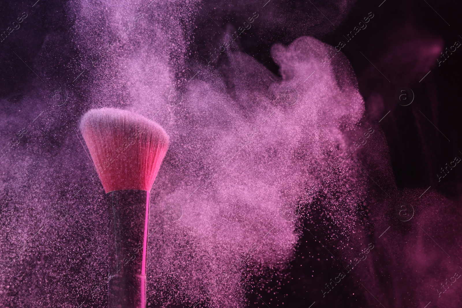Makeup brush with pink eye shadow in neon light on black background, closeup. Space for text Photo of Makeup brush with pink eye shadow in neon light on black background, closeup. Space for text