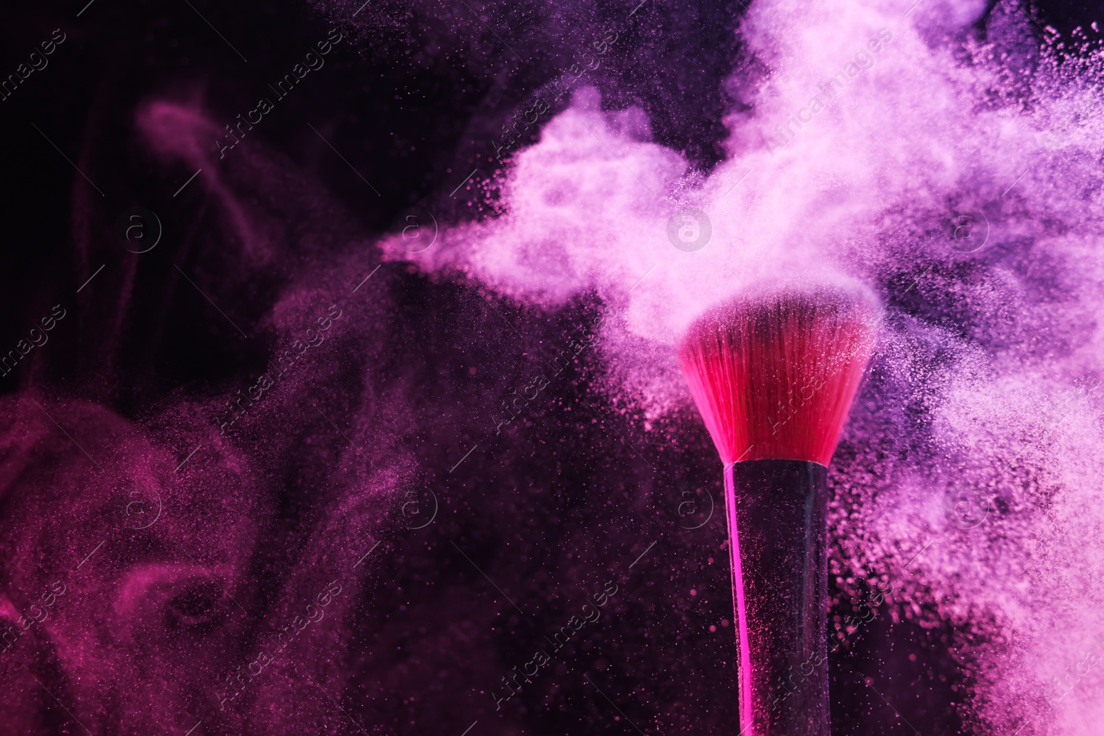 Makeup brush with pink eye shadow in neon light on black background, closeup. Space for text Photo of Makeup brush with pink eye shadow in neon light on black background, closeup. Space for text