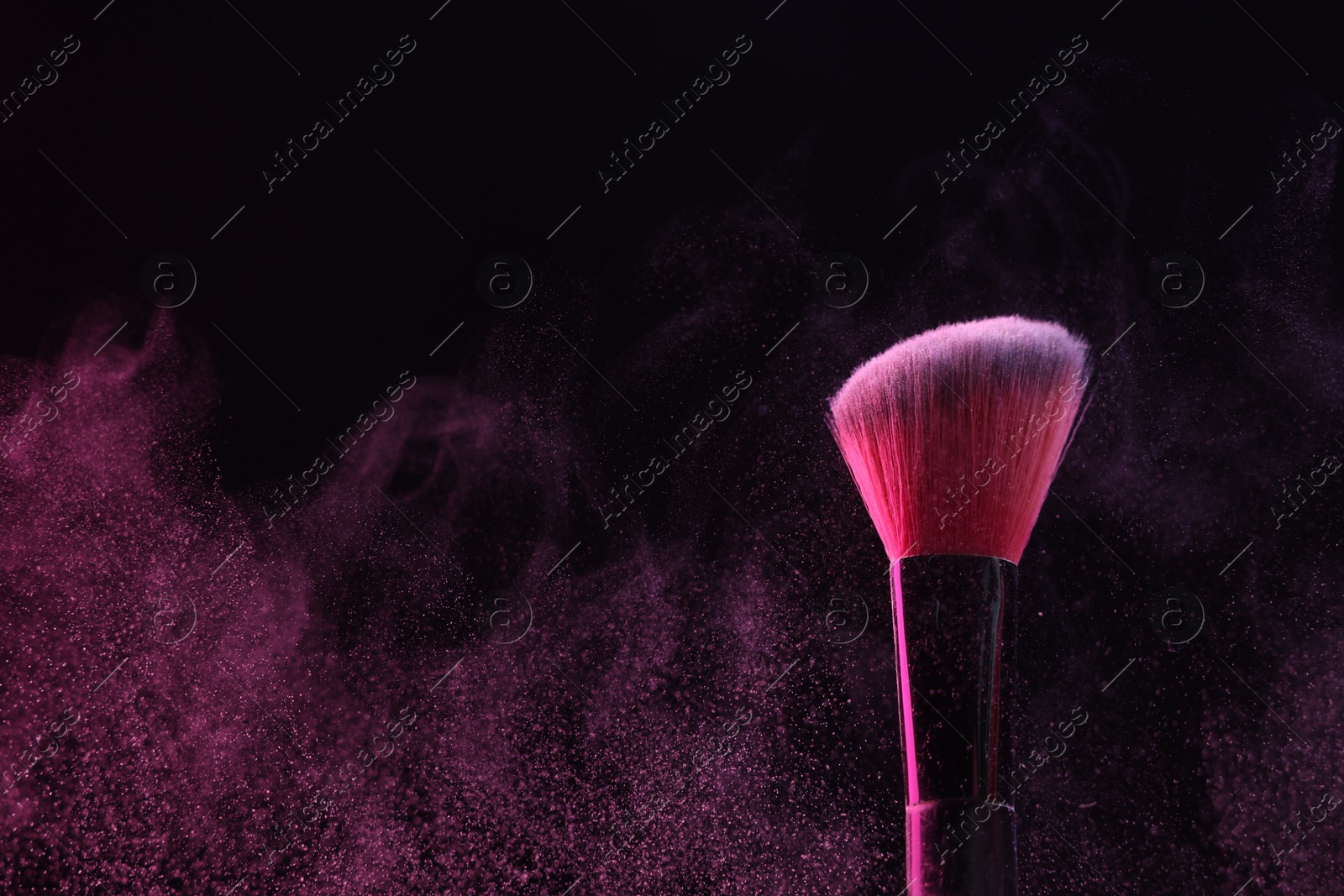 Makeup brush with pink eye shadow on black background, closeup Photo of Makeup brush with pink eye shadow on black background, closeup
