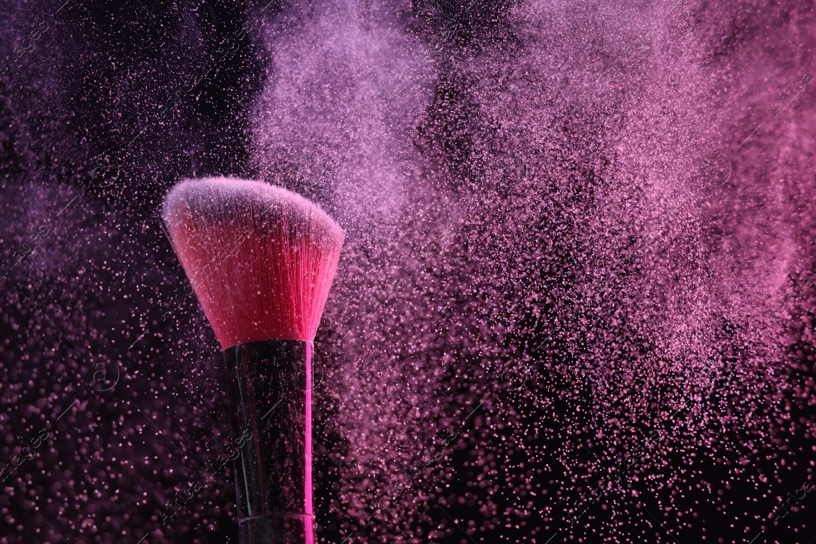 Makeup brush with pink eye shadow on black background, closeup Photo of Makeup brush with pink eye shadow on black background, closeup