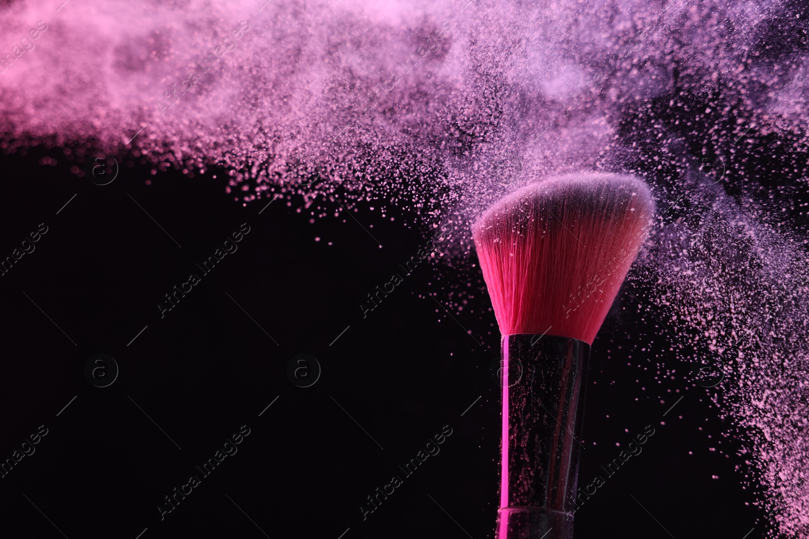 Makeup brush with pink eye shadow on black background, closeup Photo of Makeup brush with pink eye shadow on black background, closeup