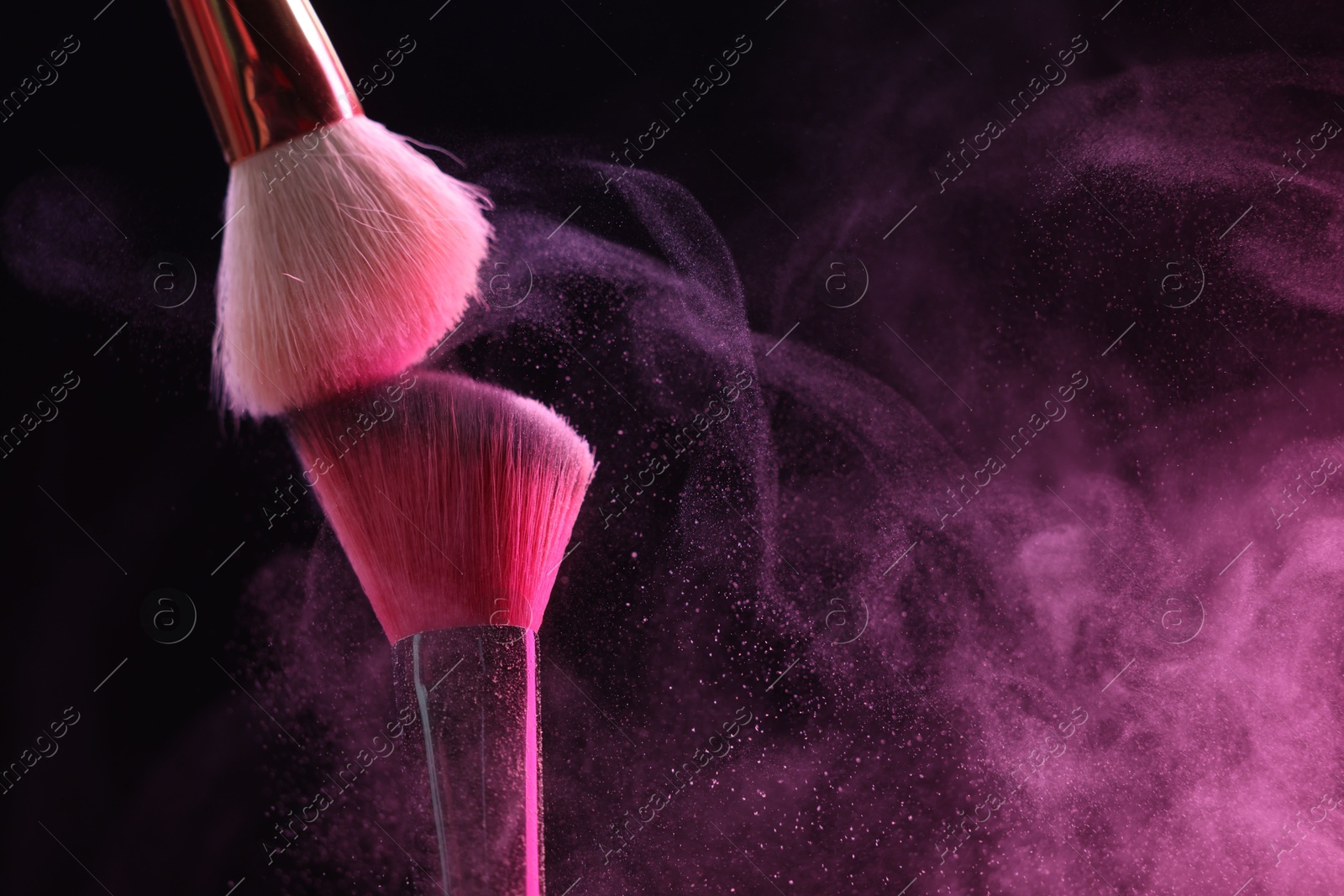 Makeup brushes with pink eye shadow on black background, closeup. Space for text Photo of Makeup brushes with pink eye shadow on black background, closeup. Space for text