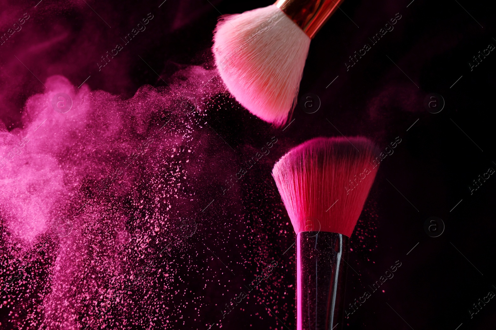 Makeup brushes with pink eye shadow in neon lights on black background, closeup. Space for text Photo of Makeup brushes with pink eye shadow in neon lights on black background, closeup. Space for text