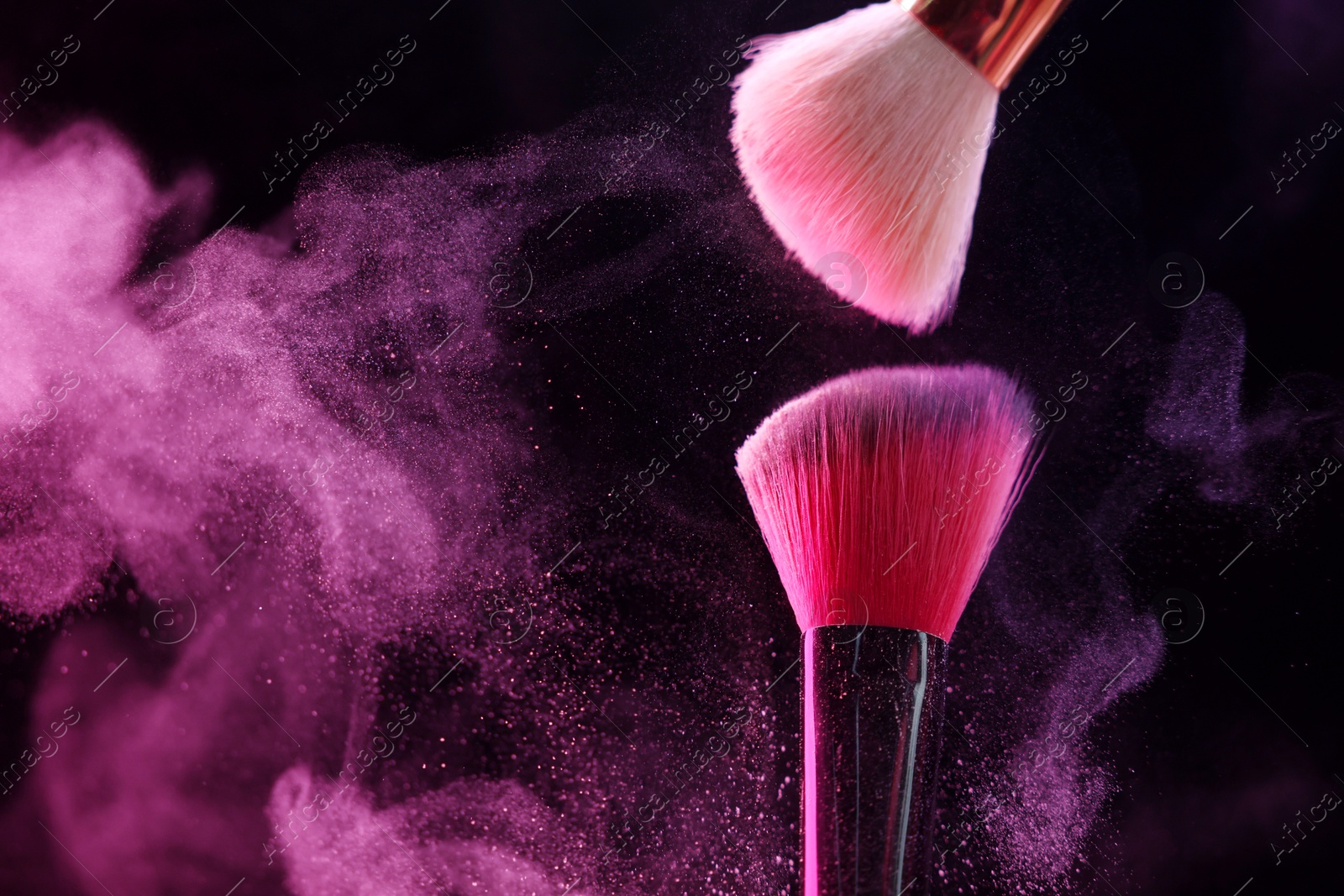 Makeup brushes with pink eye shadow in neon lights on black background, closeup. Space for text Photo of Makeup brushes with pink eye shadow in neon lights on black background, closeup. Space for text