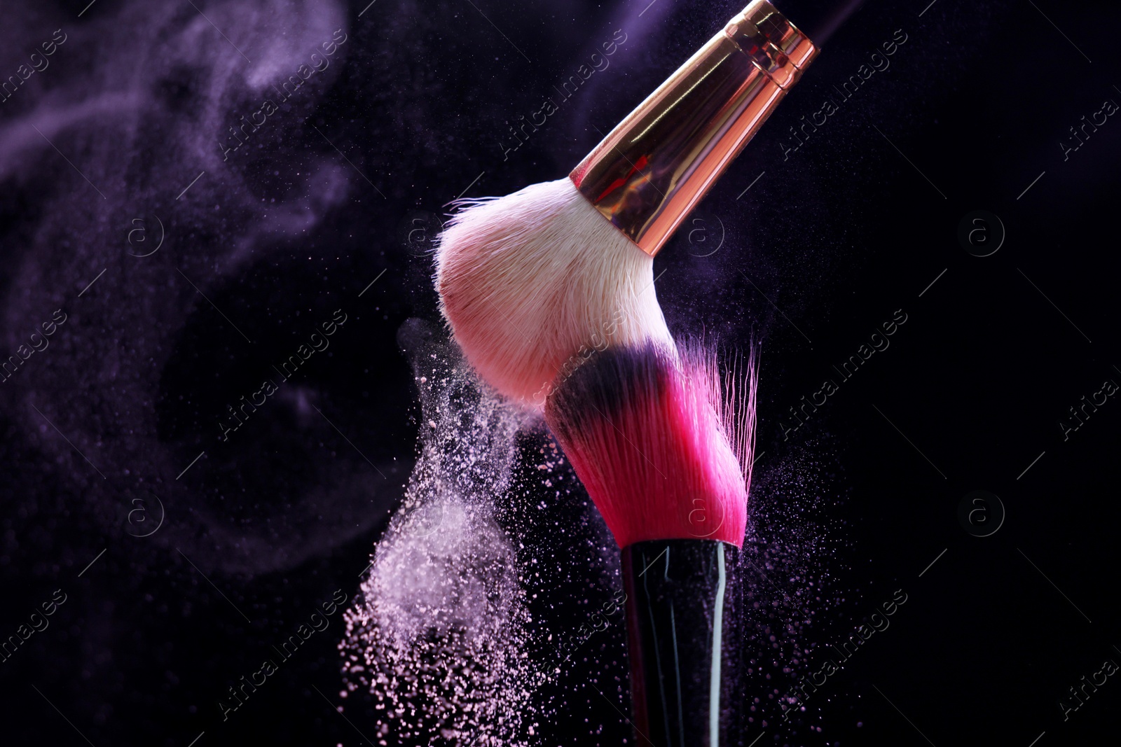 Makeup brushes with purple eye shadow on black background, closeup Photo of Makeup brushes with purple eye shadow on black background, closeup