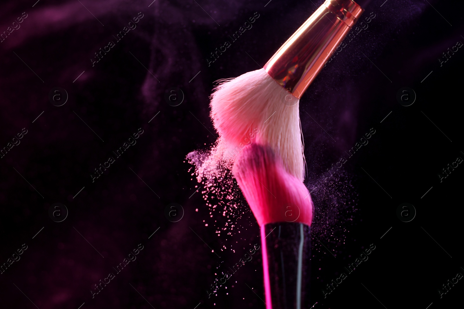 Makeup brushes with colorful eye shadows in neon lights on black background, closeup. Space for text Photo of Makeup brushes with colorful eye shadows in neon lights on black background, closeup. Space for text