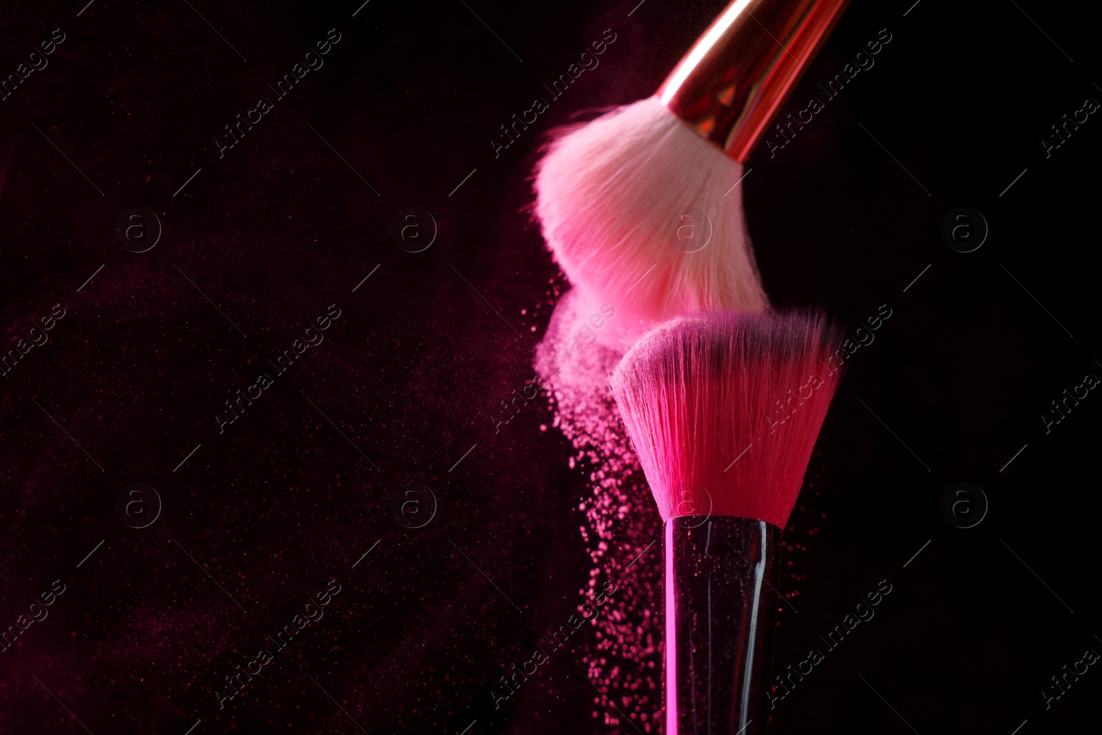 Makeup brushes with pink eye shadow on black background, closeup. Space for text Photo of Makeup brushes with pink eye shadow on black background, closeup. Space for text