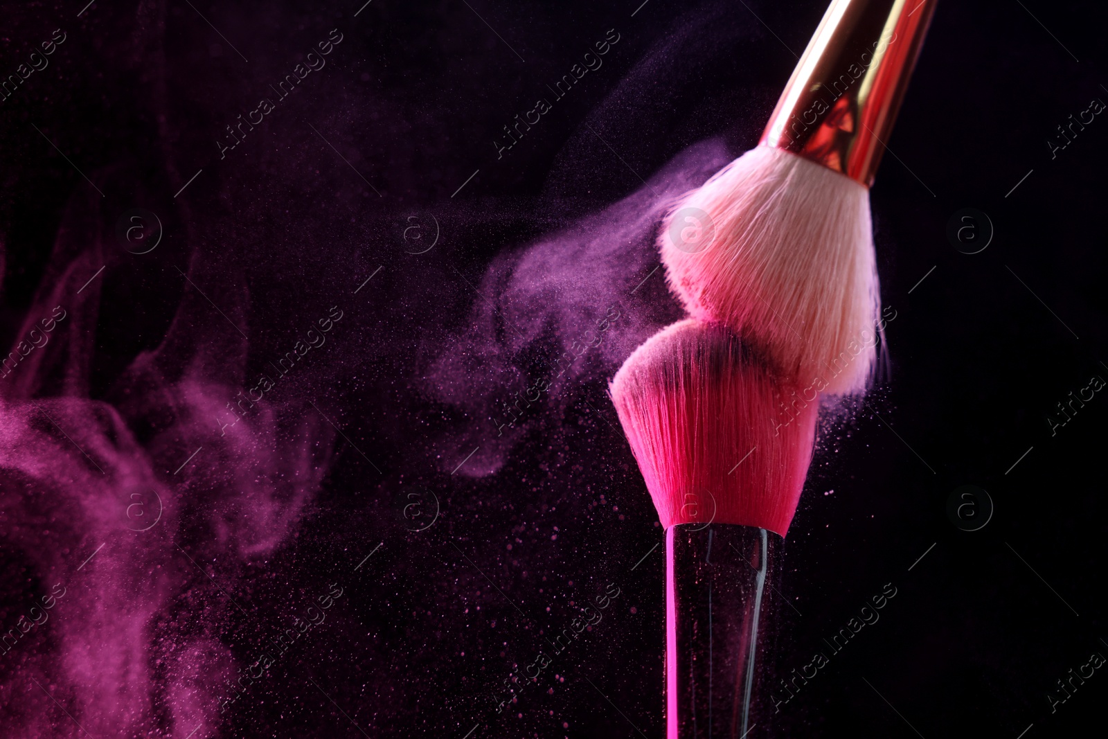 Makeup brushes with pink eye shadow on black background, closeup. Space for text Photo of Makeup brushes with pink eye shadow on black background, closeup. Space for text