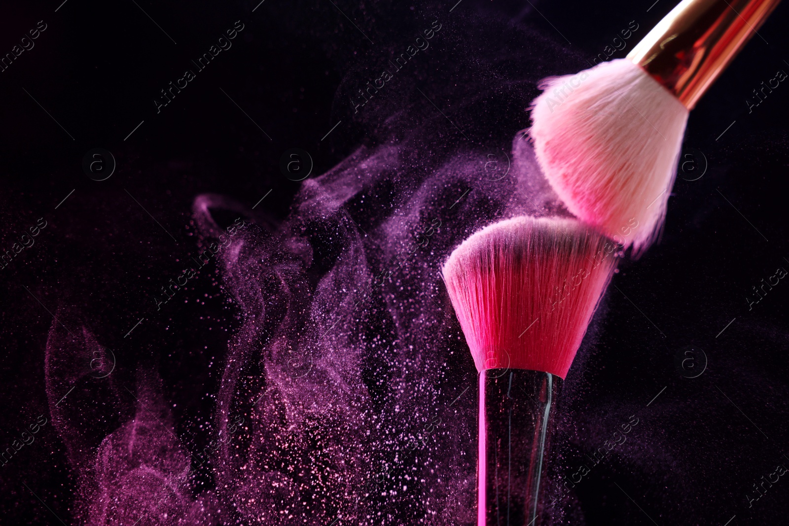 Makeup brushes with pink eye shadow on black background, closeup. Space for text Photo of Makeup brushes with pink eye shadow on black background, closeup. Space for text