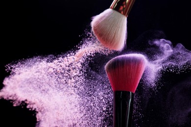 Photo of Makeup brushes with colorful eye shadows on black background, closeup. Space for text