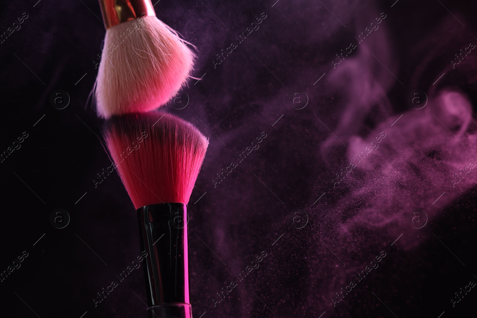 Makeup brushes with pink eye shadow on black background, closeup. Space for text Photo of Makeup brushes with pink eye shadow on black background, closeup. Space for text
