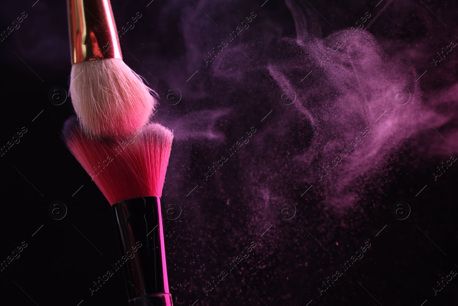 Makeup brushes with colorful eye shadows in neon lights on black background, closeup. Space for text Photo of Makeup brushes with colorful eye shadows in neon lights on black background, closeup. Space for text