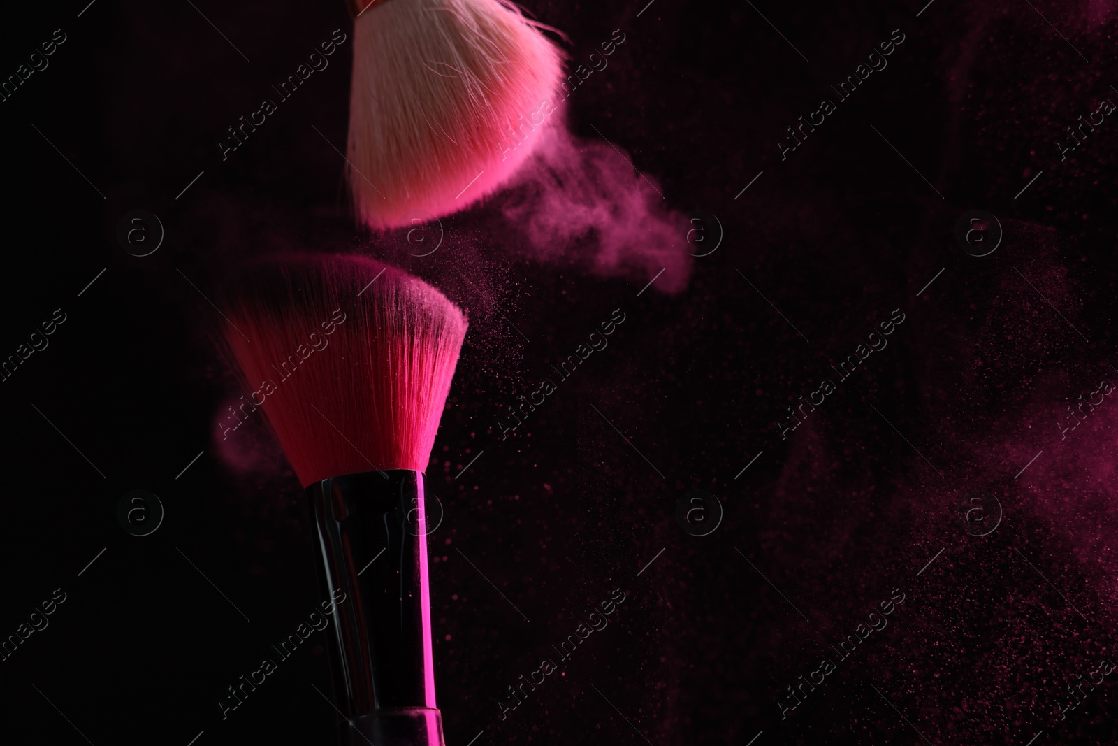 Makeup brushes with pink eye shadow on black background, closeup. Space for text Photo of Makeup brushes with pink eye shadow on black background, closeup. Space for text