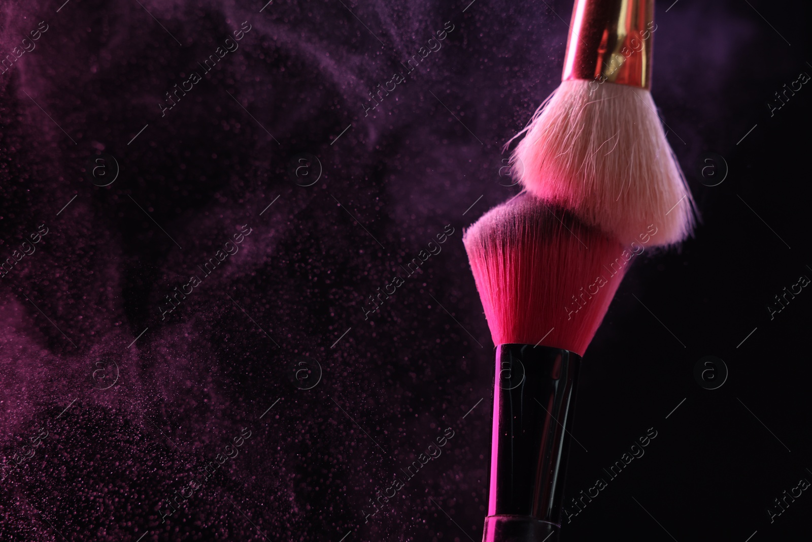 Makeup brushes with pink eye shadow on black background, closeup. Space for text Photo of Makeup brushes with pink eye shadow on black background, closeup. Space for text