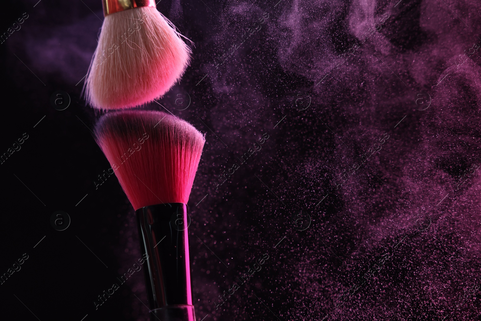 Makeup brushes with pink eye shadow on black background, closeup. Space for text Photo of Makeup brushes with pink eye shadow on black background, closeup. Space for text