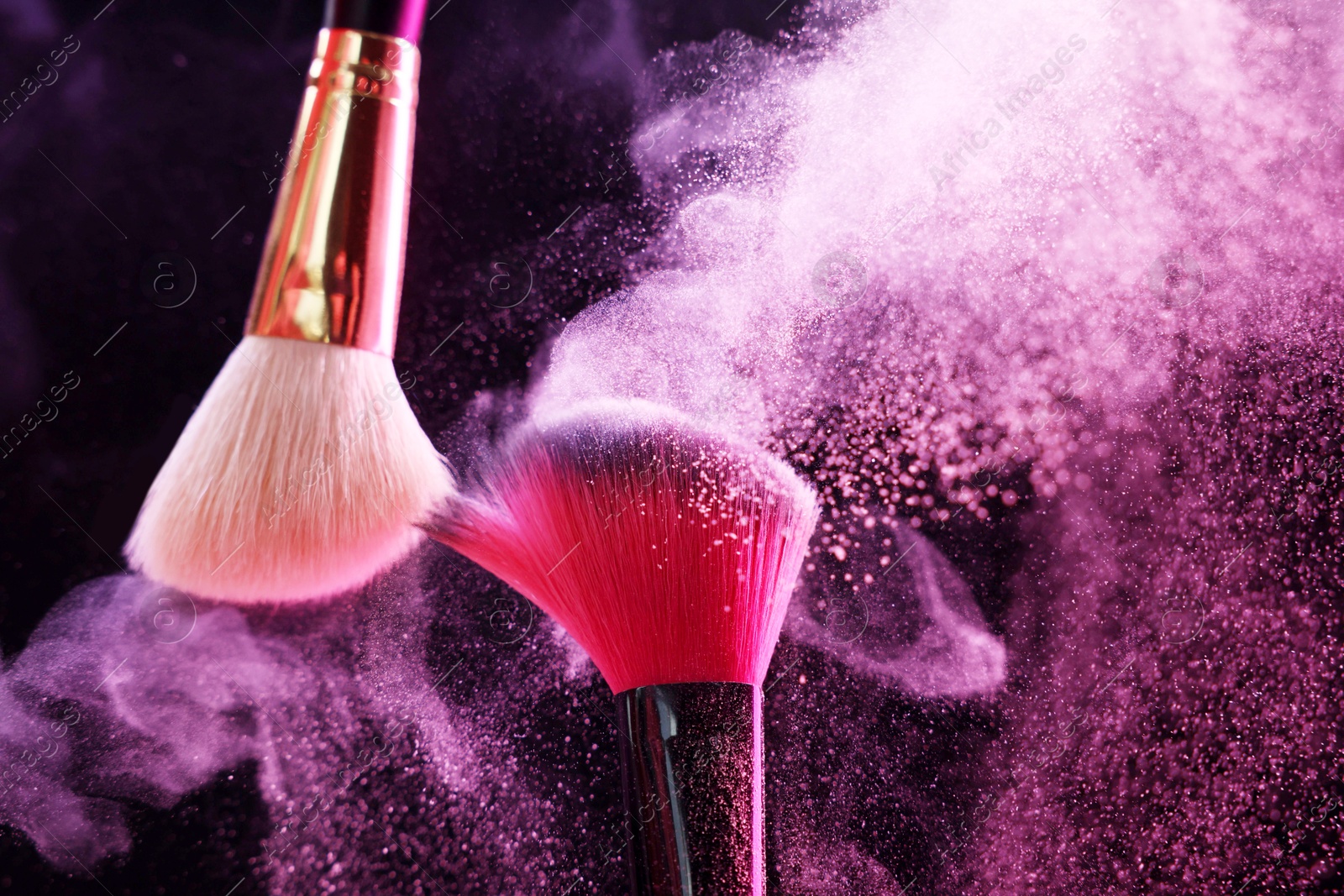 Makeup brushes with colorful eye shadows in neon lights on black background, closeup Photo of Makeup brushes with colorful eye shadows in neon lights on black background, closeup