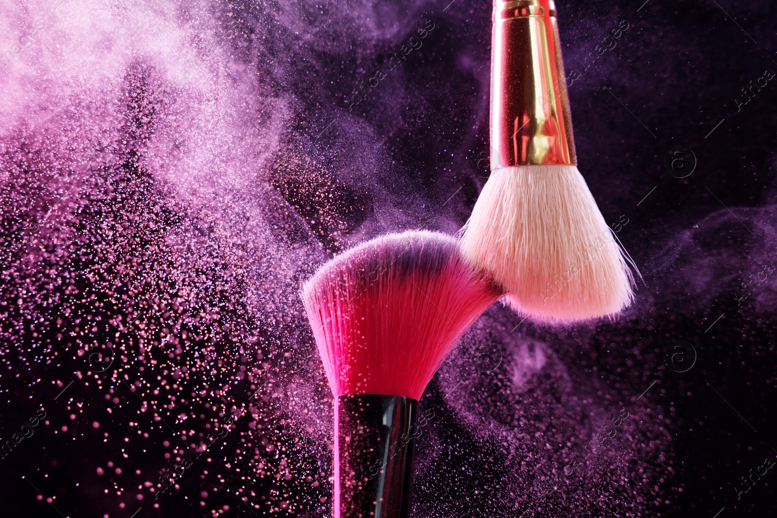 Makeup brushes with colorful eye shadows in neon lights on black background, closeup Photo of Makeup brushes with colorful eye shadows in neon lights on black background, closeup