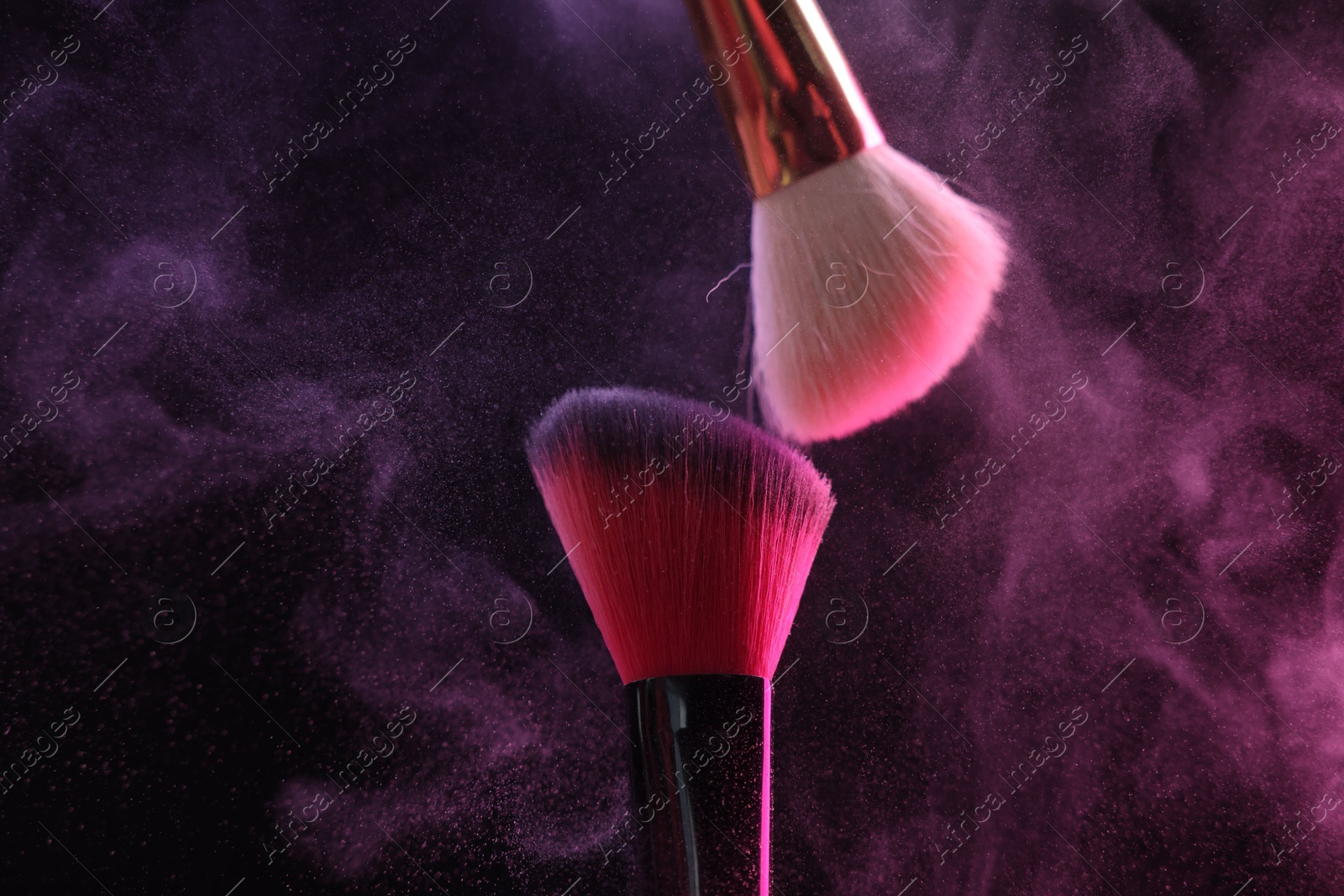 Makeup brushes with colorful eye shadows in neon lights on black background, closeup Photo of Makeup brushes with colorful eye shadows in neon lights on black background, closeup