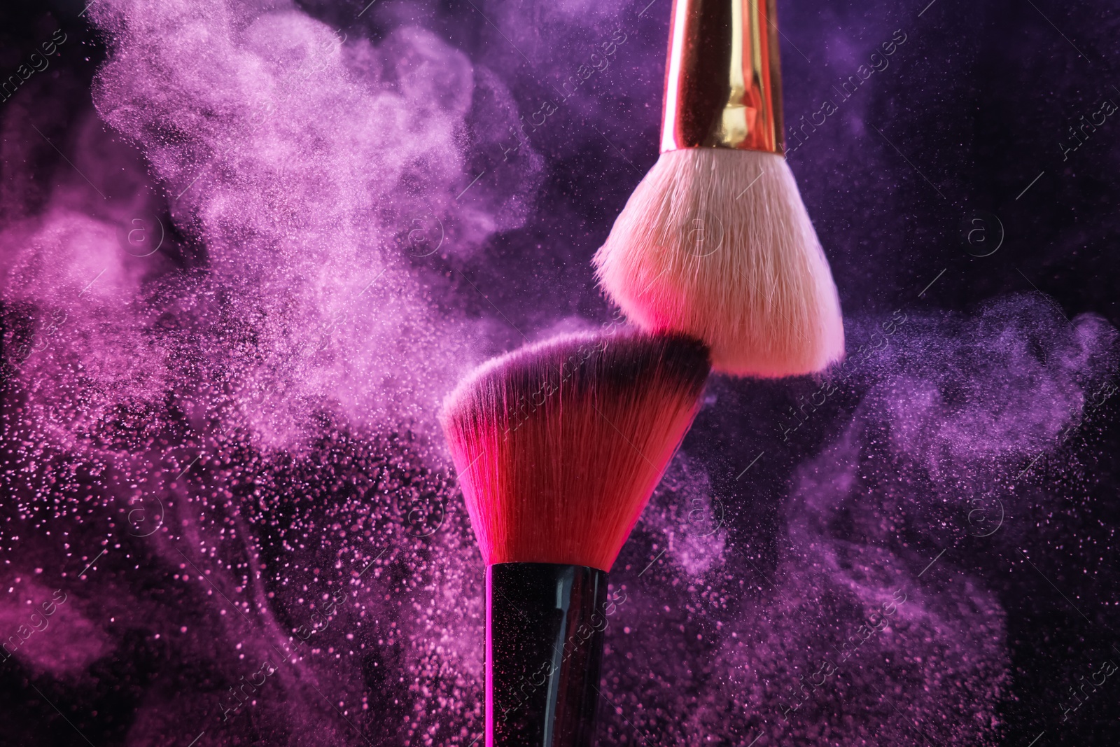 Makeup brushes with colorful eye shadows in neon lights on black background, closeup Photo of Makeup brushes with colorful eye shadows in neon lights on black background, closeup