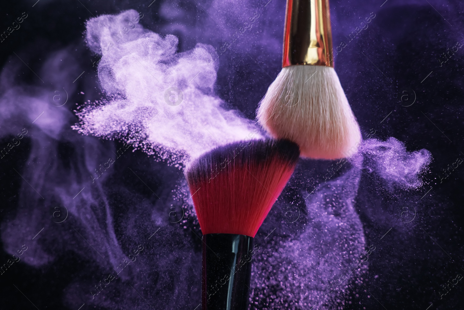 Makeup brushes with purple eye shadow on black background, closeup Photo of Makeup brushes with purple eye shadow on black background, closeup
